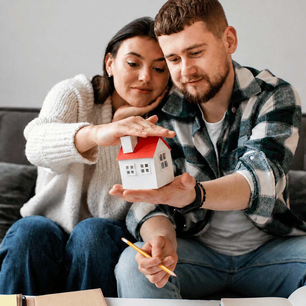 Pareja sosteniendo una pequeña casa