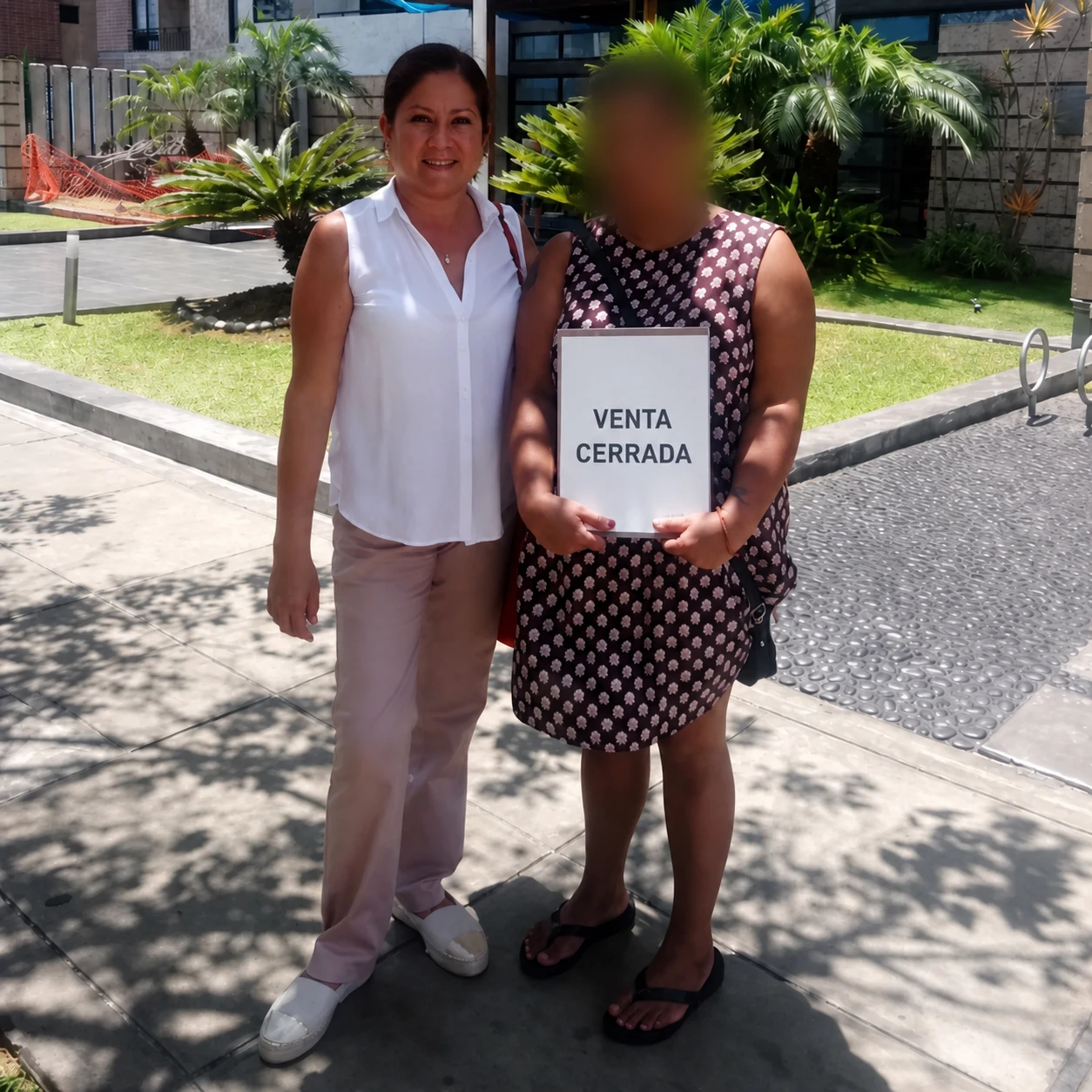 Martha junto a una clienta frente a un edificio residencial.